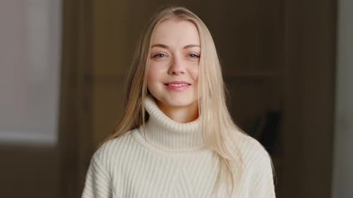 Blonde Woman Smiles Wearing Sweater Indoors