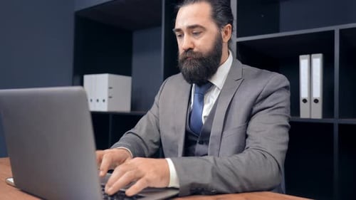 Portrait Middle Aged Businessman Using Laptop in Office