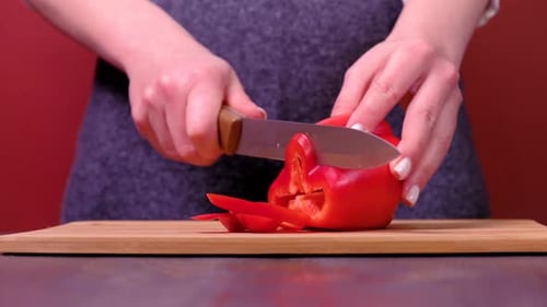 Adult Slicing Red Bell Pepper with Sharp Knife