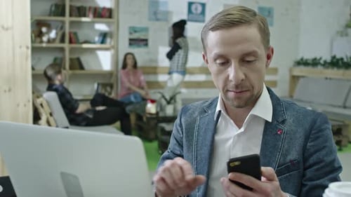 Stylish Office Worker Using Laptop and Talking on Phone