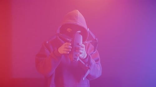 um criminoso em uma máscara com um quadcopter nas mãos