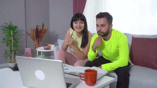 Couple Working Together at Home on Laptop