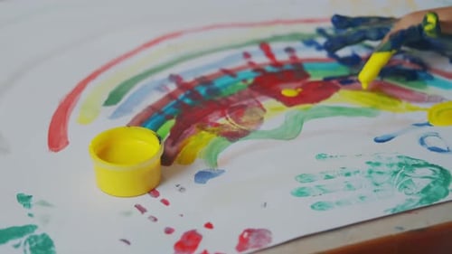 Child Painting Colorful Rainbow with Fingers