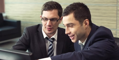 Businessmen Collaborating on Computer in Modern Office