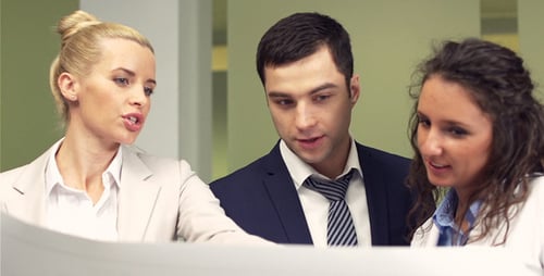 Three Colleagues Discussing Plans in Office Building