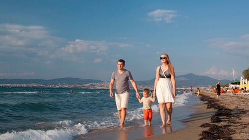 Young Family Walking On the Beach