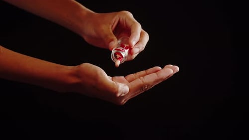 Red and White Capsules Poured into Hand