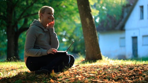 Woman Working on Laptop Outdoors, Talking on Phone