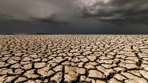 Desert Landscape with Cracked Earth Under Storm Clouds.