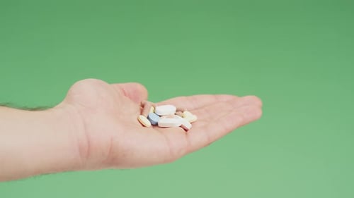 Taking a pill from a hand with meds