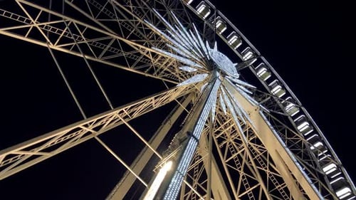 Illuminated Ferris Wheel Turning at Night