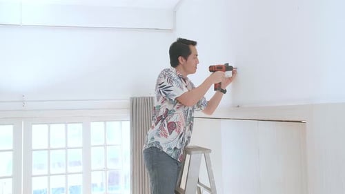 Man Installing Security Camera with Power Drill