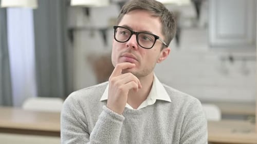 Nachdenklicher junger Mann denkt an neue Idee
