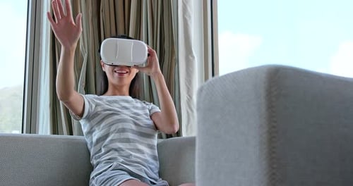 Woman Experiencing Virtual Reality on Couch at Home
