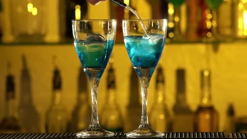 Barman Puts Cubes of Ice Into a Glass, Pouring Three Different Alcohol Liquids, Turquoise, Using