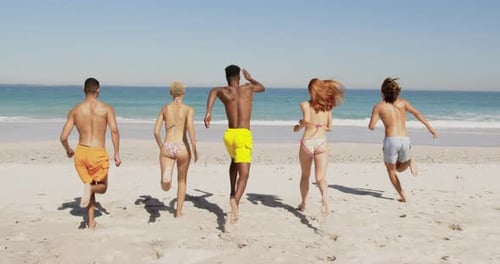 Young adult friends running at the beach 4k