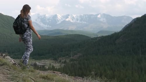 Successful Girl Tourist on the Peak of the Mountain Raises His Hands Up