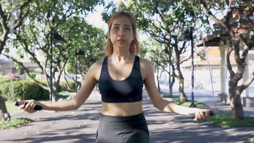 Woman Doing Rope Skipping in the Park