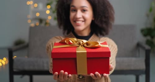 Woman Holding a Wrapped Christmas Present