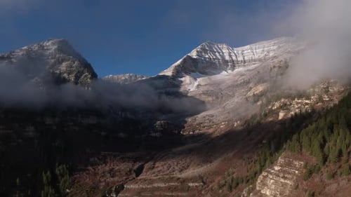 Panning aerial view of snow capped mountain