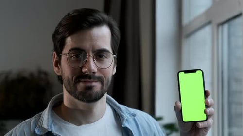 Close-Up Of a man with Glasses Using a Smartphone with a Green screen Online