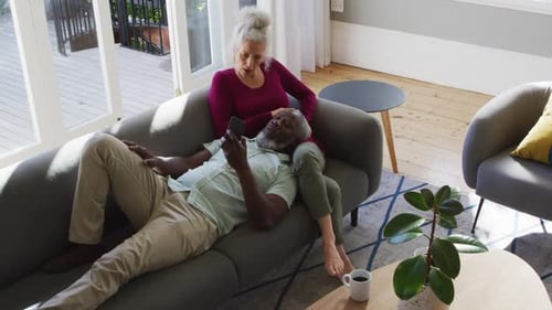 Senior Couple Relaxing at Home Using Smartphone