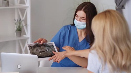 Dentist Explains X-Ray to Patient in Clinic