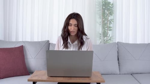 Woman Working on Laptop and Taking Notes