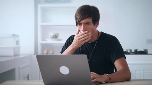 Shocked Young Adult Using Laptop Indoors