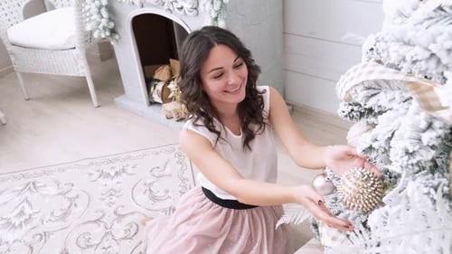 Woman Decorating Christmas Tree in Cozy Home