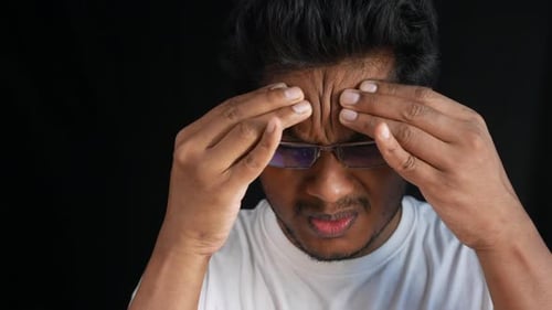 Young Man Massaging Temples with a Headache