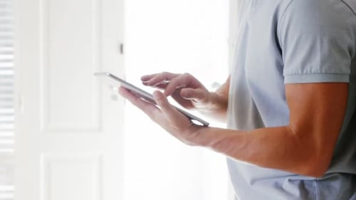 Man Using Tablet Device Smiling Indoors