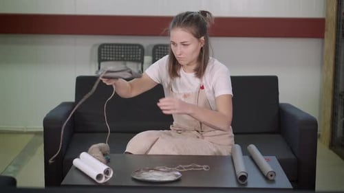 Artist Woman Is Packaging Ceramic Plate in Craft Paper, Tightening By Rope