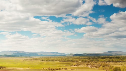 Aerial View of Rolling Fields and Distant Mountains