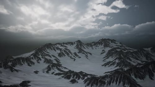 Dramatic Aerial View of Snow-Covered Mountain Range with Cloudy Sky