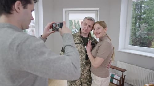 Man Takes Photo of Couple in Camouflage Uniform