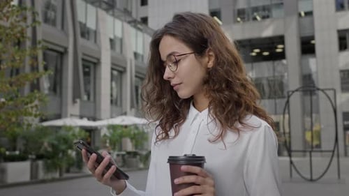 Young Girl Takes Break While Working With Coffee On The Street
