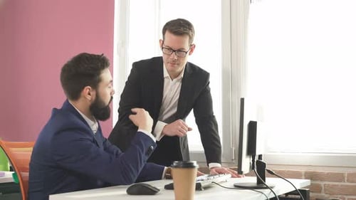 Businessmen Working Together at Computer in Modern Office