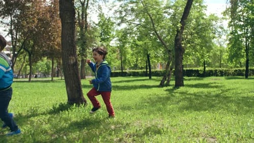 Excited Little Friends Running through Park
