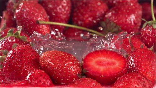 Strawberry Falling in Water Between Strawberries