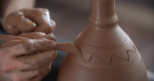 Potter Draws a Curved Line on a Rotating Jug on a Potter's Wheel Video From Pottery Workshop Potter