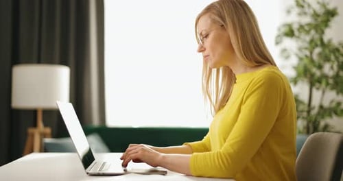 Woman Working on Laptop at Home During Day