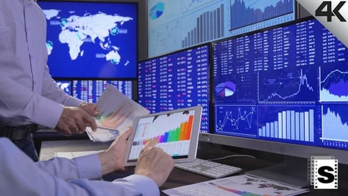 Financial Analysts Analyzing Data on Multiple Monitors