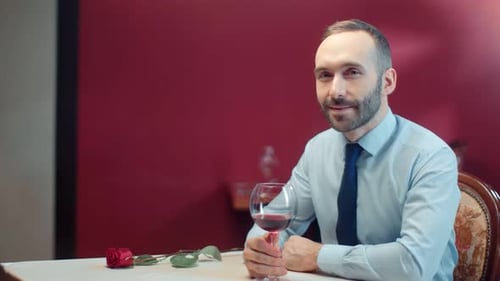 Man With Wine and Rose Waiting at Table
