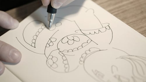 Hand Drawing Character on White Paper with Black Pen