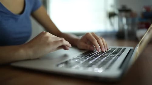 Woman typing on laptop computer at home