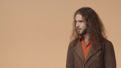 Impressed Funny Bearded Man with Long Curly Hair Seeing Something Awesime and Cool Turn Head Back to