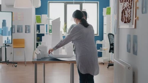 Team of Diverse Architects Working Together on Building Model Design with Blueprints