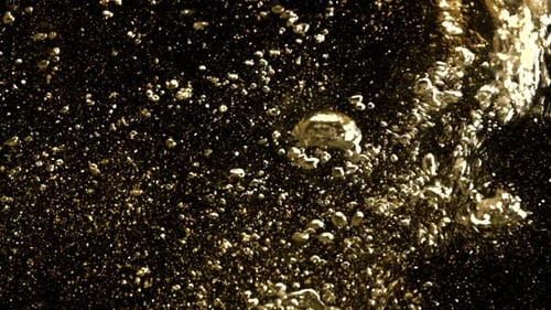 Golden Glitter Underwater Background. Gold Particles Shining in Water on Black Background. Gold Dust