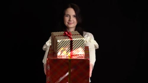 Woman Holding Two Gifts on Black Background